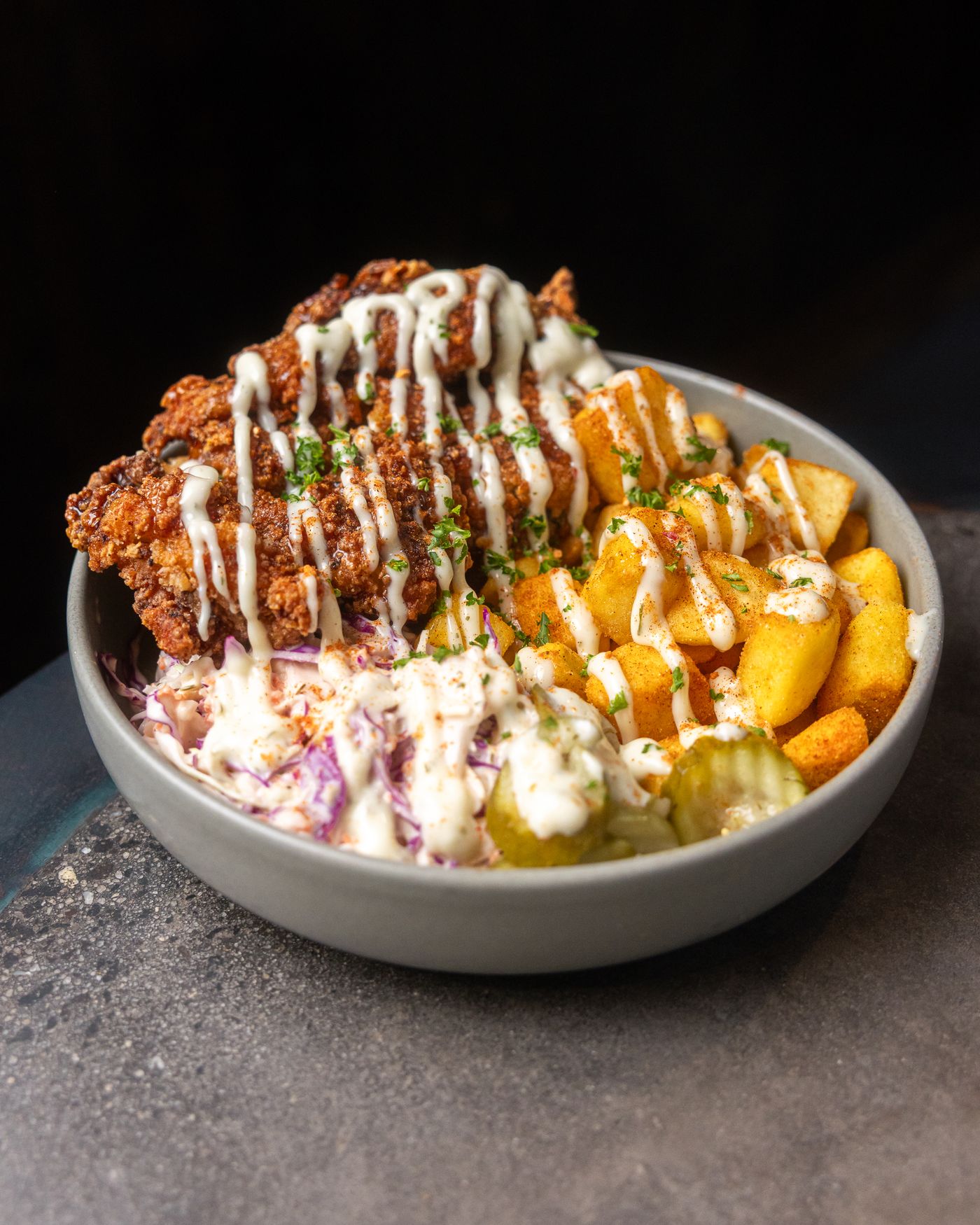 Loaded fries bowl with crispy fried chicken, slaw, pickles and sauce