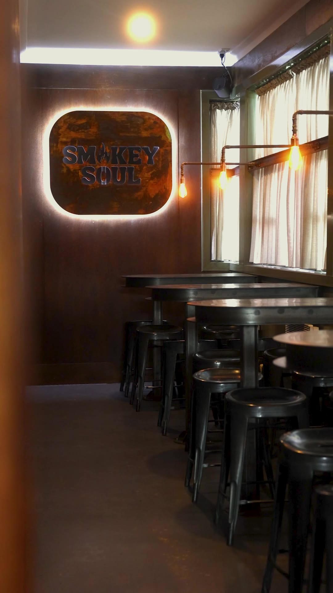Inside Smokey Soul restaurant with backlit logo and bar seating, Footscray
